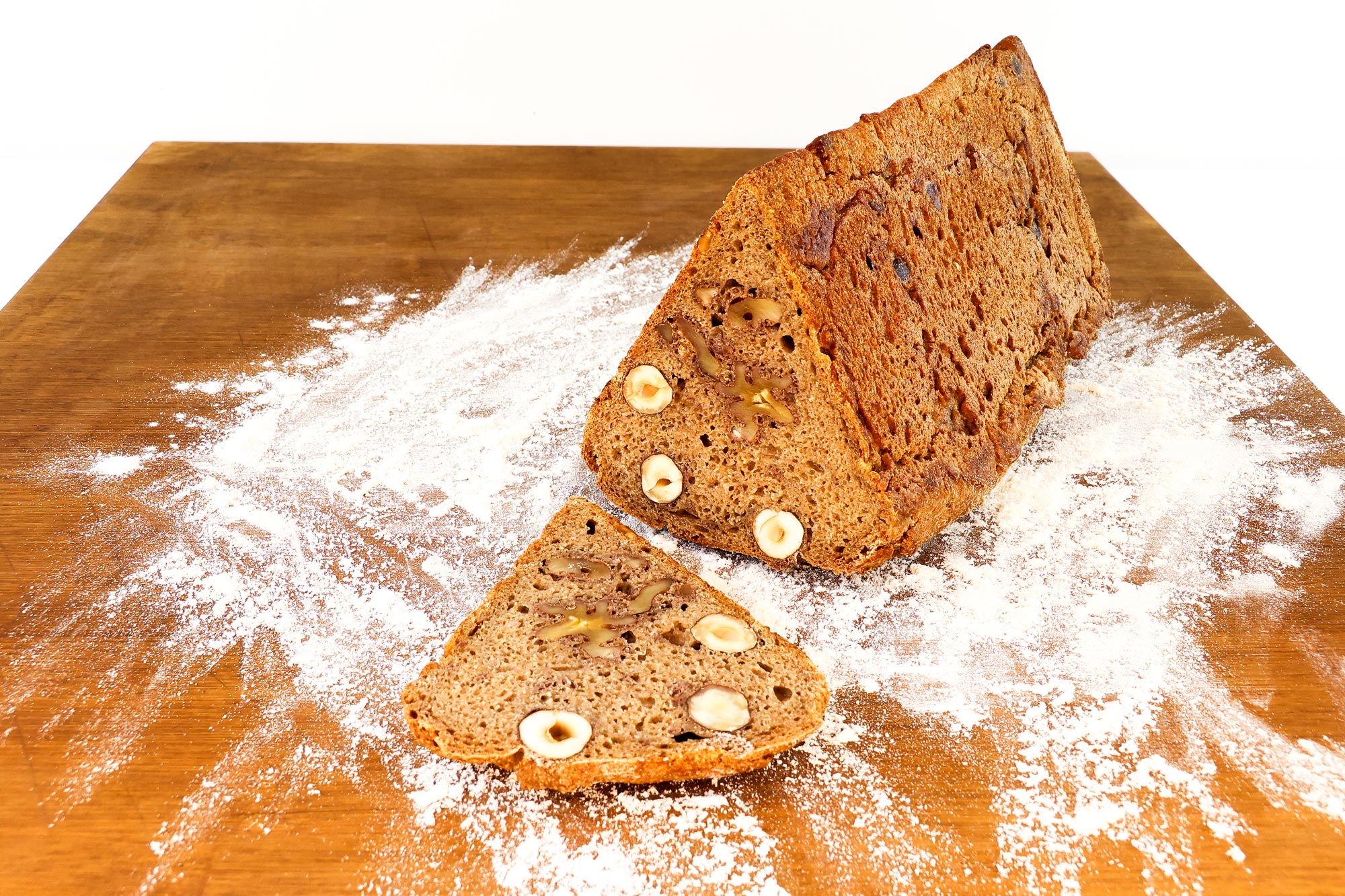 Angeschnittenes Nussbrot der Bäckerei Krämer mit ganzen Haselnüssen und Walnüssen in der dunklen Krume